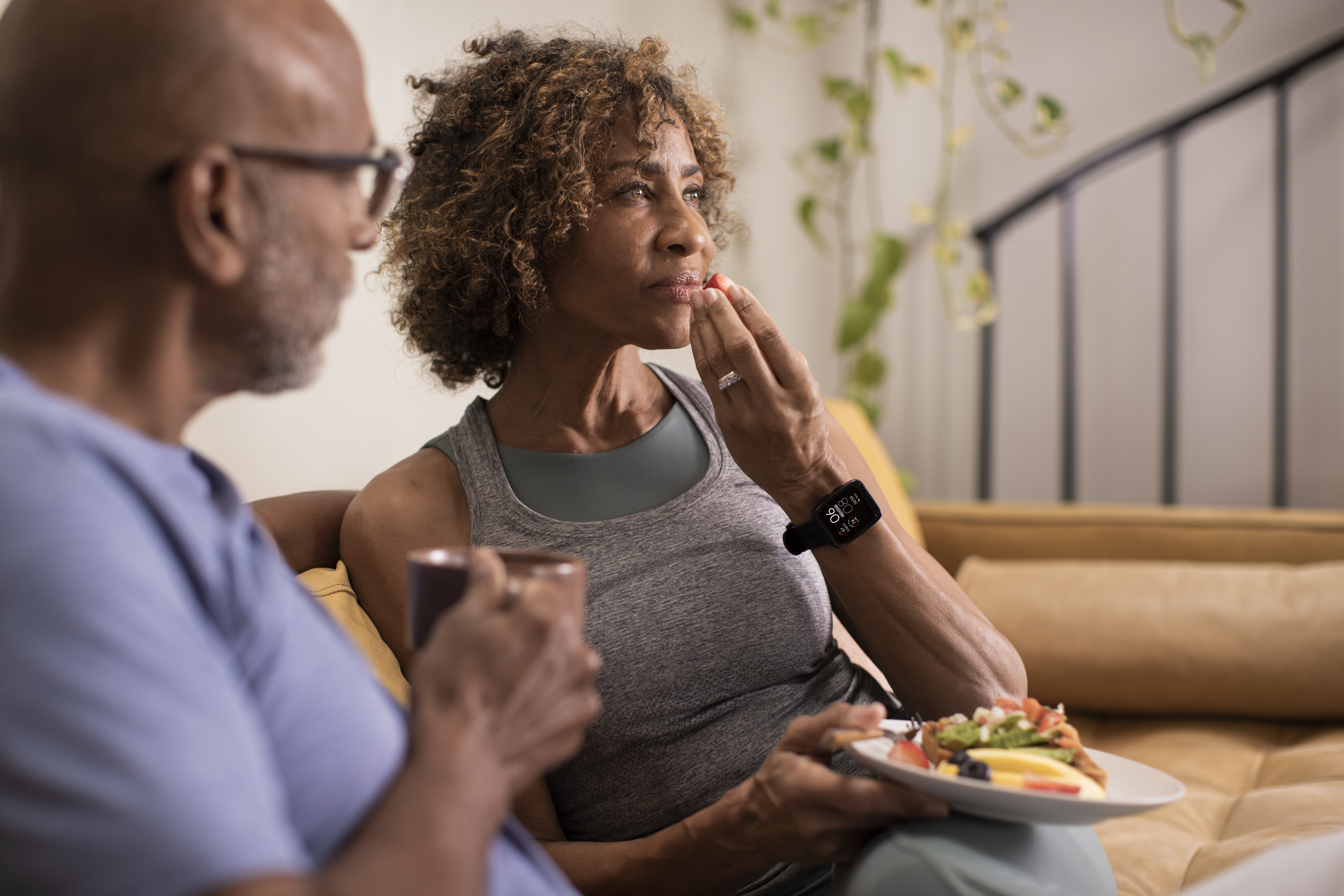 Couple sitting on couch with one individual wearing Masimo W1 on wrist