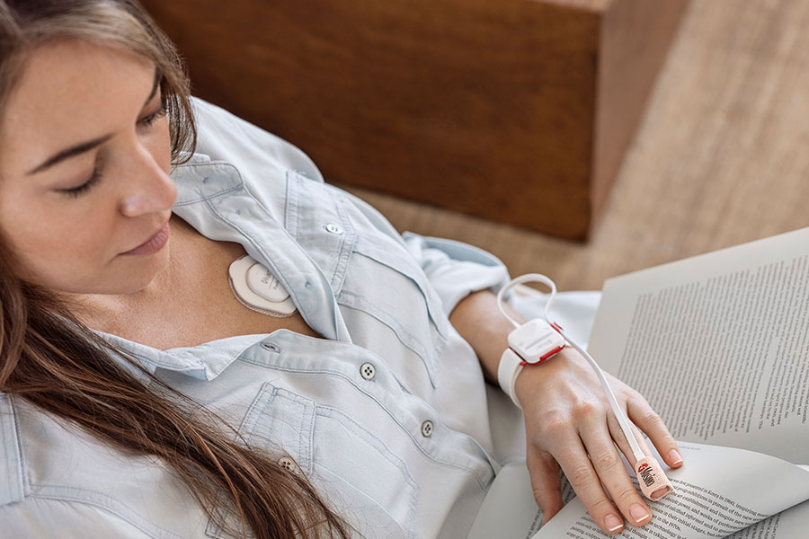 Masimo - Woman relaxing with Radius PPG and Radius T devices