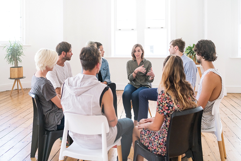 individuals sitting in chairs in a group setting