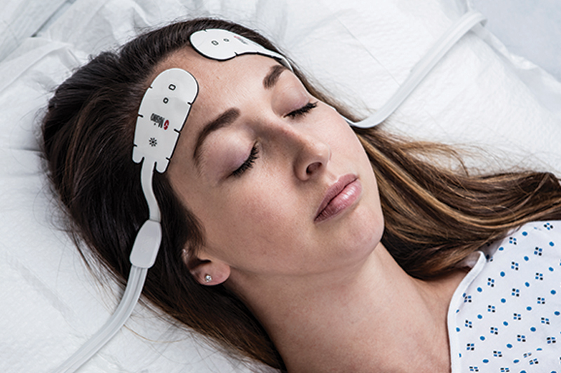 Adult patient sleeping in bed wearing Masimo O3 Sensors.
